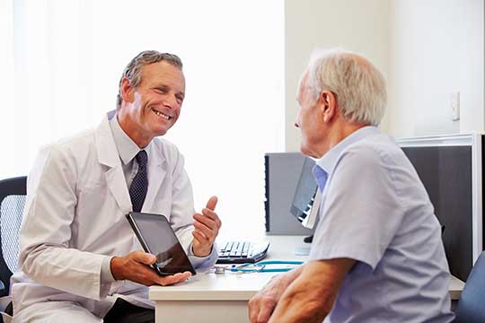 Older man talking to his doctor about how to manage his tinnitus