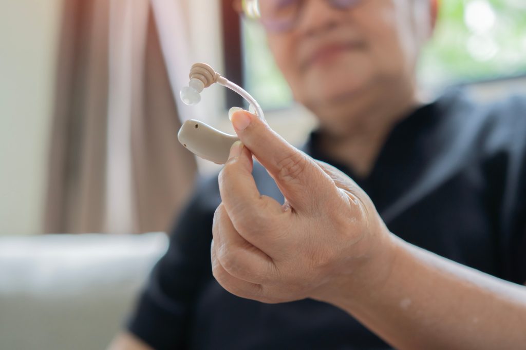 Person holding a hearing aid.